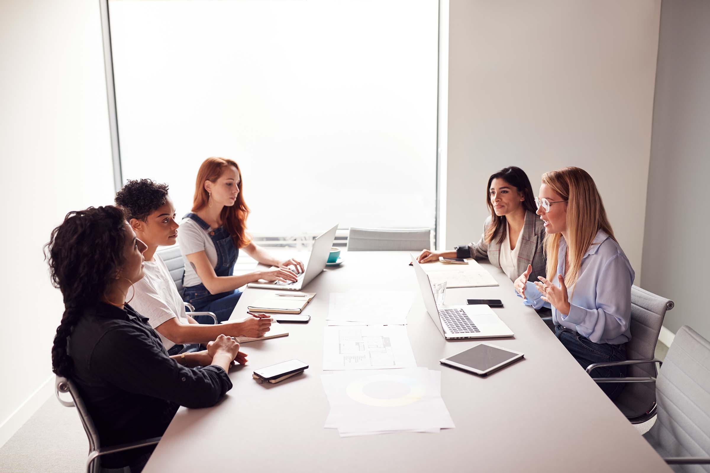 team-of-young-businesswomen-in-meeting-around-tabl